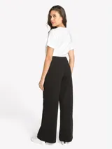 Pantalón negro de tiro alto Tommy Hilfiger de pernera ancha, con detalles de tres botones dorados en los laterales y cierre frontal.