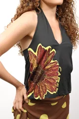 Top de cuello halter con estampado de rayas verticales en tonos granate, beige y mostaza. Confeccionado en tejido elástico, presenta un corte ajustado y diseño sin mangas.