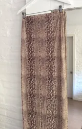 Pollera larga de microtul con estampado animal print de serpiente en tonos marrones, de corte ajustado y cintura elástica.