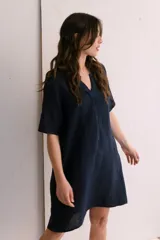 Vestido corto color arena de lino, con cuello en V y mangas cortas.