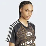 Remera Adidas Originals de satén con estampado animal print, cuello en V acanalado y mangas cortas negras con las clásicas tres tiras blancas. Cuenta con el logo de la marca estampado en el frente.