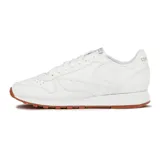 Championes Reebok Classic Leather blancos con suela de goma color caramelo y detalles en rojo.