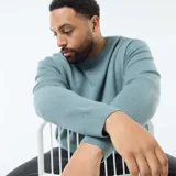 Sweater de punto gofrado, color azul verdoso, de manga larga y cuello redondo.