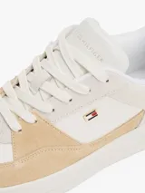 Zapatillas urbanas Tommy Hilfiger de corte bajo, color blanco con detalles en beige y amarillo. Presentan el logo de la marca en el lateral y están confeccionadas en piel, nailon y poliuretano.