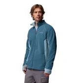 Campera polar con cierre frontal completo, cuello alto y mangas largas con orificios para pulgares. Presenta un diseño en dos tonos de azul con paneles laterales en un tono más claro y logo de la marca bordado en el pecho.