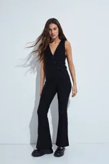Pantalón de corte oxford, color negro, con ajuste en la cadera y pierna acampanada hacia el bajo. Presenta una silueta fluida y entallada.