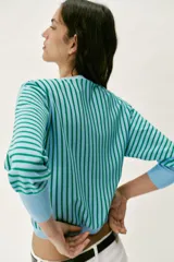 Sudadera de punto con cuello redondo y manga larga, de diseño a rayas verticales celestes y verdes, con puños y ribetes lisos en color celeste.