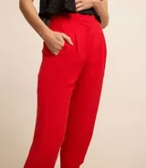 Pantalón zanahoria de tiro alto color rojo, con cierre tradicional, pliegues y botón en el bajo.