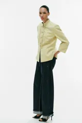 Blazer de jacquard color amarillo claro, con cuello mao, mangas 3/4 y cierre frontal con alamares. Presenta diseño estampado de inspiración oriental.
