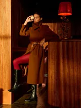 Bota de caña alta con taco medio, confeccionada en una combinación de cuero napa y cuero con textura croco. Presenta un diseño de estilo hípico con hebilla y apliques metálicos decorativos, panel trasero elastizado para mayor ajuste y cierre lateral interno.