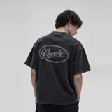 Remera oversize de algodón con acabado stonewash y efecto desgastado, con logo ovalado retro estampado en la espalda.