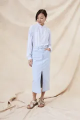 Camisa de manga larga con cuello mao y estampado a rayas verticales celestes y blancas.