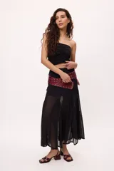 Falda midi color borgoña, de corte recto con aberturas frontales y transparencias.