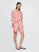 Short de lino a rayas verticales color amarillo y blanco, con cintura elastizada y cordón ajustable.