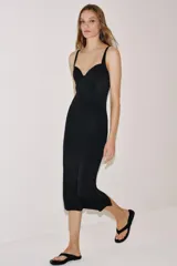 Vestido midi negro con escote corazón, aros y tirantes anchos. Presenta una combinación de tejidos con laterales de malla transparente, corte ajustado y bajo recto.
