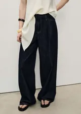 Pantalón de denim azul oscuro, de corte wide leg, tiro medio y diseño largo. Cuenta con cinco bolsillos, trabillas y cintura deshilachada.