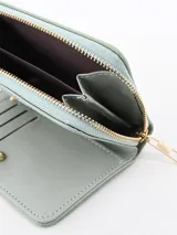 Billetera pequeña color verde con diseño acolchado a cuadros y cierre con cremallera dorada.