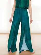 Mono de vestir verde esmeralda con estampado abstracto, escote en V, mangas cortas y pantalón palazzo con aberturas laterales.