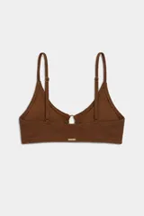 Top de bikini amarillo con textura sutil y detalle de aros metálicos entrelazados en el centro del escote, con tirantes finos.