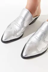 Zapato plateado estilo tejano sin talón, realizado en cuero vacuno con diseños de cortes y costuras a contra tono.