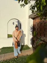 Buzo de tejido de punto color beige, de corte holgado y mangas largas.