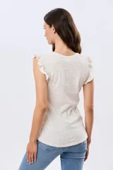 Musculosa blanca con estampado floreado sutil y volados en los hombros, de corte recto.
