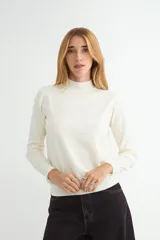 Polera de punto de manga larga con cuello alto, diseño ajustado y acabado liso.