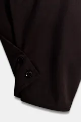 Camiseta oversize de cuello redondo y manga larga con puños abotonados. Confeccionada en algodón, presenta un diseño con combinación de tejidos a tono y bajo asimétrico.