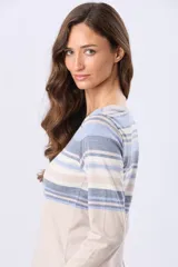 Remera de algodón con poliéster, de manga larga, con estampado de rayas horizontales en tonos beige, azul claro, azul grisáceo y blanco. Tiene un corte clásico y escote redondo.