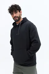 Canguro de algodón color celeste claro, con capucha ajustable mediante cordones trenzados blancos y bolsillo canguro frontal. Presenta un pequeño texto estampado en el pecho.