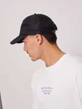 Gorra trucker Rusty con visera gris, frente blanco con logo estampado y malla trasera gris.