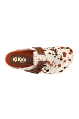 Zueco de cuero con estampa tipo animal print de vaca, con tira de ajuste marrón y hebilla metálica. Plantilla anatómica y suela de corcho y goma.