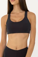 Top deportivo negro con espalda abierta y breteles finos. Cuenta con una banda inferior en la cintura y espacio para agregar tazas.