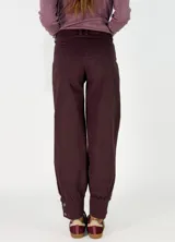 Pantalon de gabardina en color azul oscuro, de corte holgado con botamangas ajustadas mediante elástico.