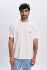 Remera oversize de manga corta en color blanco, con cuello redondo y un pequeño parche cuadrado con diseño de sol en el pecho.