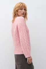 Sweater de punto con diseño de trenzas verticales, color rosa melange, de cuello redondo y manga larga con puños acanalados.