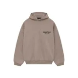 Hoodie con capucha color gris topo, de corte oversize, con bolsillo canguro frontal y etiqueta de goma de la marca en la capucha. Presenta el logo 'ESSENTIALS FEAR OF GOD' estampado en negro en el pecho.