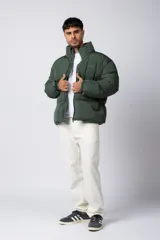 Campera puffer de corte relajado en color verde oscuro, con cuello alto, cierre frontal completo y logo bordado en el pecho.