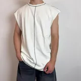 Musculosa de corte oversize color blanco con costuras expuestas en color negro que recorren el centro y los hombros.