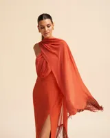 Vestido midi de fiesta color naranja, con escote asimétrico y chal incorporado con flecos.