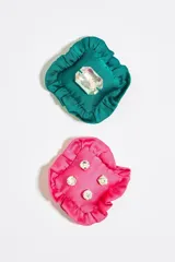 Par de aros asimétricos con forma de cojín de tela satinada, uno color verde esmeralda con un cristal rectangular facetado y otro color fucsia con cuatro cristales redondos. Cierre a presión.