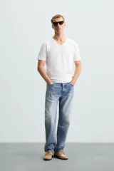 Camiseta blanca de algodón con elasticidad, corte slim fit, cuello en V y mangas cortas.