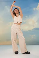 Pantalón beige de crepe de sastrería con lurex, tiro alto, corte sastrero, pinzas delanteras y pretina elastizada en la espalda.
