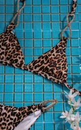 Conjunto de bikini fucsia con corpiño triangular y bombacha clásica con argollas plateadas con strass en los laterales.