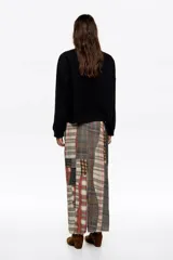Jersey de lana color negro, de corte boxy y diseño holgado, con escote redondo, manga larga recta y bolsillos de plastrón en el pecho.