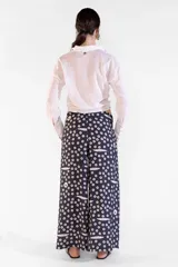 Camisa de manga larga color blanco crema, confeccionada en 100% algodón, con cuello camisero, botones nacarados y diseño con largo para anudar al frente.