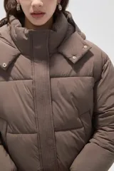 Campera puffer negra con capucha, manga larga, cierre frontal y cuello alto.