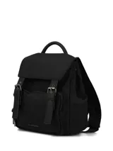 Mochila urbana negra de diseño compacto, confeccionada en material sintético con acabado mate. Presenta una solapa superior con correas decorativas y hebillas metálicas, cierre principal con cremallera, bolsillo frontal con cierre y tiradores con cordón. Incluye asa superior y correas ajustables para los hombros.