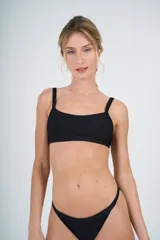 Conjunto de bikini negro de tela texturada, compuesto por un corpiño tipo top y una bombacha colaless regulable.