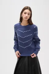 Sweater de punto color azul con diseño de fantasía en forma de líneas curvas punteadas en color celeste. Presenta cuello redondo a la base, mangas largas con puños acanalados y corte holgado.